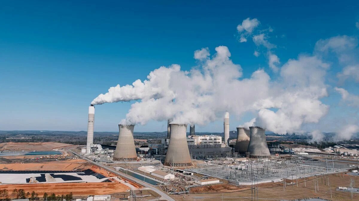 An aerial view shows a coal-fired power plant with cooling towers and smokestacks. Photo: Kelly / Pexels
