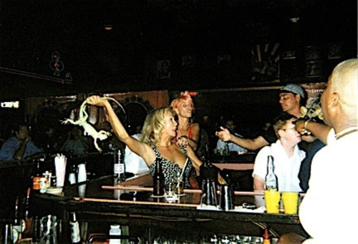 A woman named Tara swings the pet iguana that belonged to a man she had a disagreement with at Mac’s Club Deuce in the early 2000s. Former bartender Melissa Burley witnessed the drama go down.