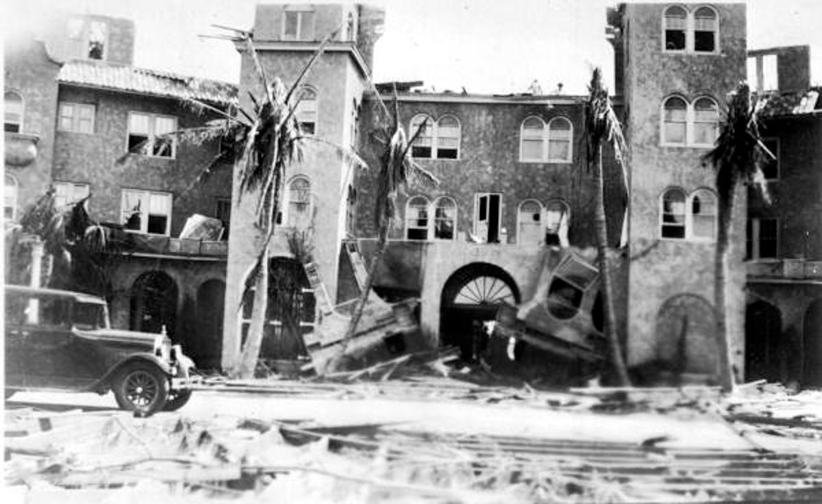 Building and road damage are seen after the Great Miami Hurricane of September 1926. The storm passed over downtown Miami and parts of Cocoanut Grove and South Miami around 630 AM on September 18. At the height of the storm surge, the water from the Atlantic extended all the way across Miami Beach and Biscayne Bay into the City of Miami for several city blocks. The Red Cross later reported that 372 persons had died in the storm and over 6,000 persons were injured.  Damages in 1926 dollars were estimated at $105 million, which would be more than $1.99 billion in today's dollars.