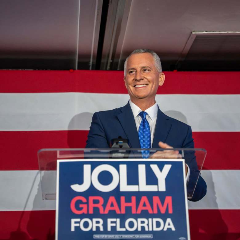 David Jolly speaking at a podium in front of an American flag with a Jolly Graham for Florida campaign sign
