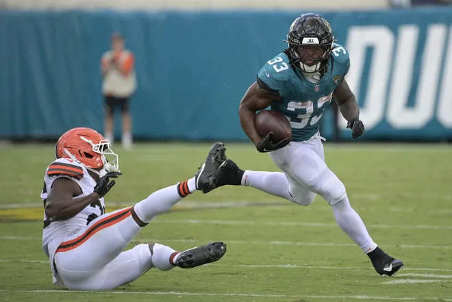 Sep 13, 2026; Jacksonville, Florida, USA; Jacksonville Jaguars running back Bhayshul Tuten (33) runs the ball against Cleveland Browns cornerback Myles Harden (26) in the third quarter at EverBank Stadium. Mandatory Credit: Melina Myers-Imagn Images