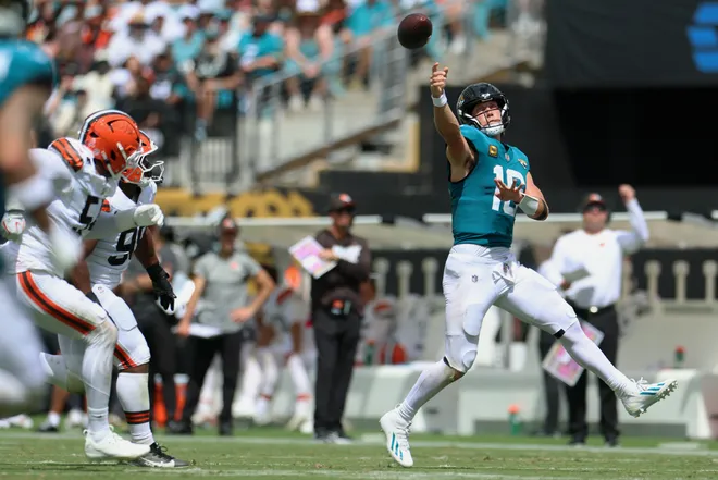 Sep 13, 2026; Jacksonville, Florida, USA; Jacksonville Jaguars quarterback Trevor Lawrence (16) attempts a pass on the run from Cleveland Browns defensive end Sam Williams (54) and defensive end Adin Huntington (98) in the second quarter at EverBank Stadium. Mandatory Credit: Nathan Ray Seebeck-Imagn Images