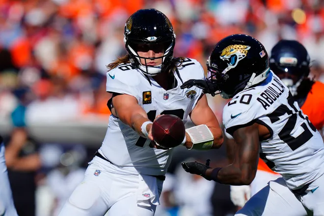 Sep 20, 2026; Denver, Colorado, USA;  Jacksonville Jaguars quarterback Trevor Lawrence (16) hands off to running back Ameer Abdullah (20) against the Denver Broncos during the second half at Empower Field at Mile High.  Mandatory Credit: Ron Chenoy-Imagn Images