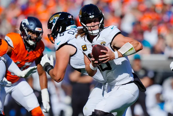 Sep 20, 2026; Denver, Colorado, USA;  Jacksonville Jaguars quarterback Trevor Lawrence (16) looks to hand off during the second half against the Denver Broncos at Empower Field at Mile High.  Mandatory Credit: Ron Chenoy-Imagn Images