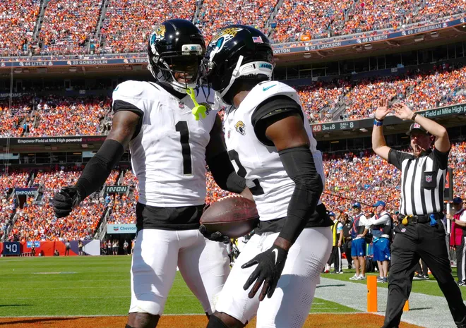 Sep 20, 2026; Denver, Colorado, USA;  Jacksonville Jaguars cornerback Jourdan Lewis (2) celebrates his interception with cornerback Montaric Brown (1) against the Denver Broncos during the second quarter at Empower Field at Mile High.  Mandatory Credit: Ron Chenoy-Imagn Images