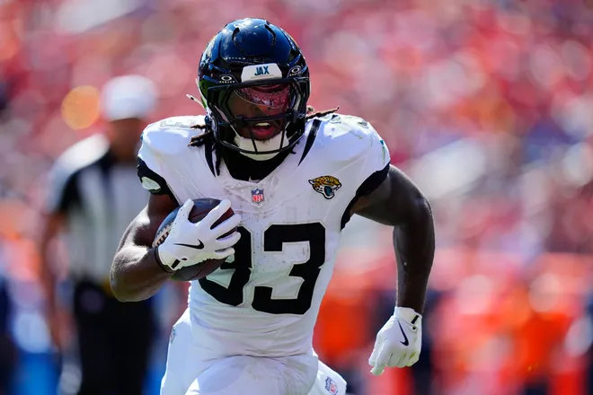 Sep 20, 2026; Denver, Colorado, USA;  Jacksonville Jaguars running back Bhayshul Tuten (33) rushes the ball against the Denver Broncos in the first half at Empower Field at Mile High.  Mandatory Credit: Ron Chenoy-Imagn Images