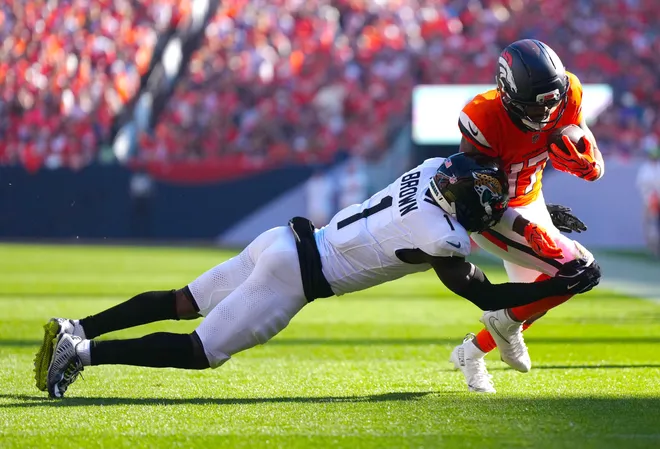 Sep 20, 2026; Denver, Colorado, USA;  Denver Broncos wide receiver Jaylen Waddle (17) is tackled by. Jacksonville Jaguars cornerback Montaric Brown (1) during the second half at Empower Field at Mile High.  Mandatory Credit: Ron Chenoy-Imagn Images