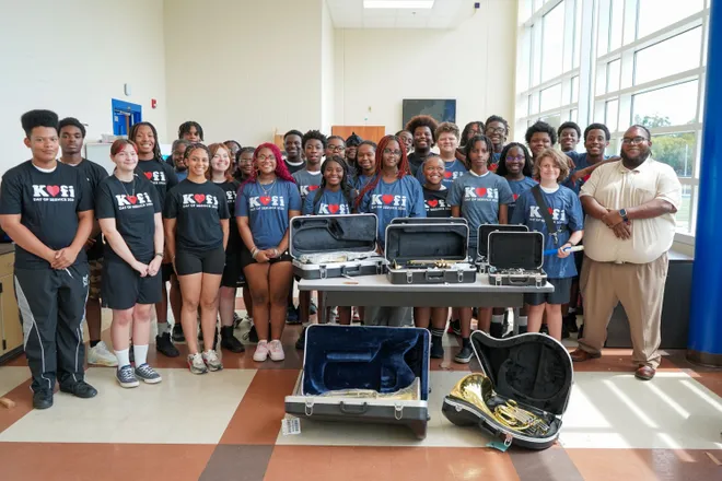 Riverside High School music students and Band Director Isaac Green, front, right, celebrate receiving about $38,500 worth of musical instruments from nonprofit Mr. Holland’s Opus Foundation.