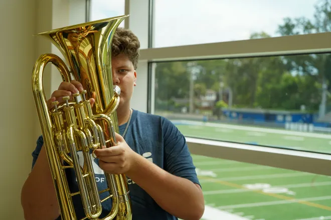 At Riverside High School, a music student tests out a tuba, one of the new instruments donated by nonprofit Mr. Holland’s Opus Foundation.