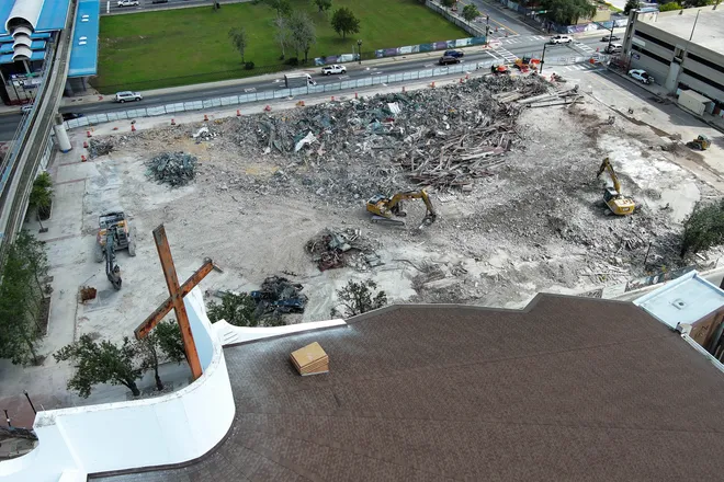 A cross from First Baptist Church of Jacksonville looms over the demolition site as construction workers used excavators to make piles and remove debris from the tear down of the First Baptist Church of Jacksonville’s old sanctuary in downtown Jacksonville, Fla. Wednesday September 23, 2026.