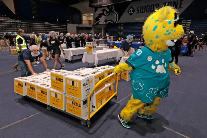 Jaguars mascot Jaxson DeVille lends a paw at a 9/11 Day meal-packing event at the University of North Florida Arena. About 700 volunteers packed meals for the Feeding Northeast Florida food bank.