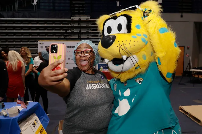 A volunteer gets a selfie with Jaguars mascot Jaxson DeVille at a recent 9/11 Day meal packing event. Jacksonville was one of 50 cities packing at least 17 million meals for Americans at risk of hunger.