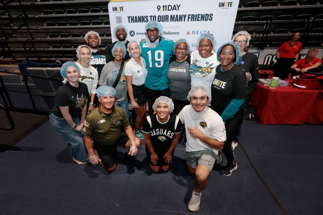 On Sept. 11, former Jacksonville Jaguar Ernest Wilford poses with some volunteers who packed meals for the Feeding Northeast Florida food bank. The effort was part of national nonprofit 9/11 Day's goal to transform the anniversary into a service day.