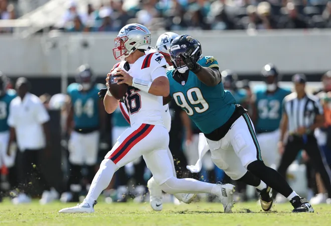 Sep 27, 2026; Jacksonville, Florida, USA; New England Patriots quarterback Tommy DeVito (16) is sacked by Jacksonville Jaguars defensive tackle Ruke Orhorhoro (99) during the fourth quarter at EverBank Stadium. Mandatory Credit: Morgan Tencza-Imagn Images