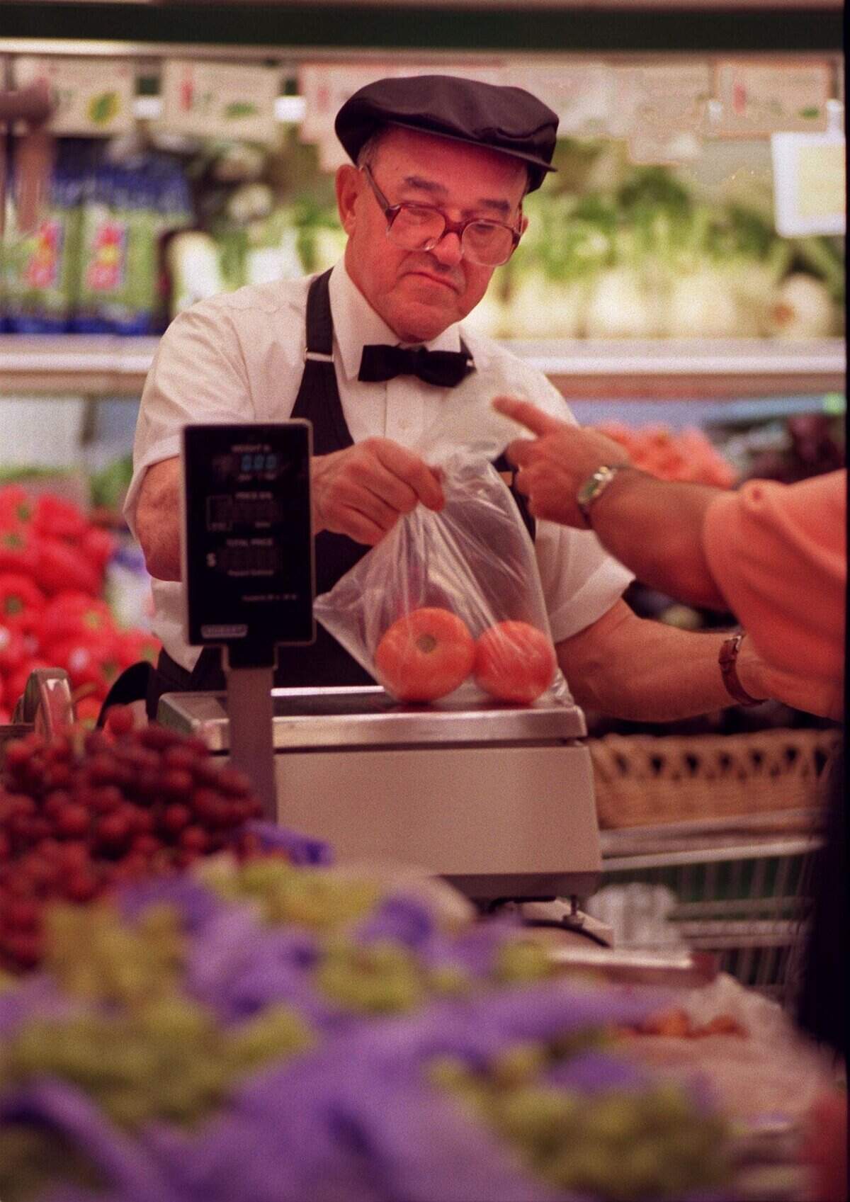 In 1998, Epicure worker Alberto Serpa weighs tomatoes for a customer.