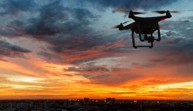 Drone flying above a city skyline at sunset beneath a cloudy sky.