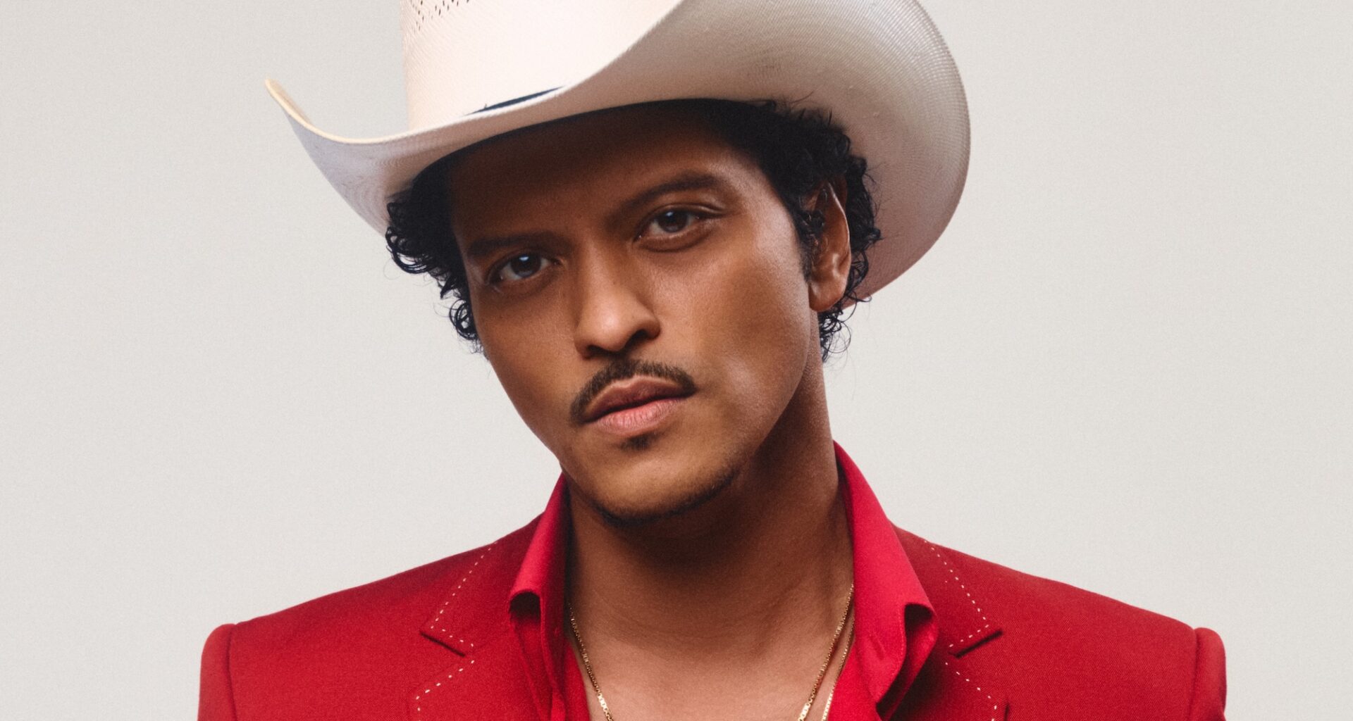 photo of Bruno Mars in a red suit and white cowboy hat