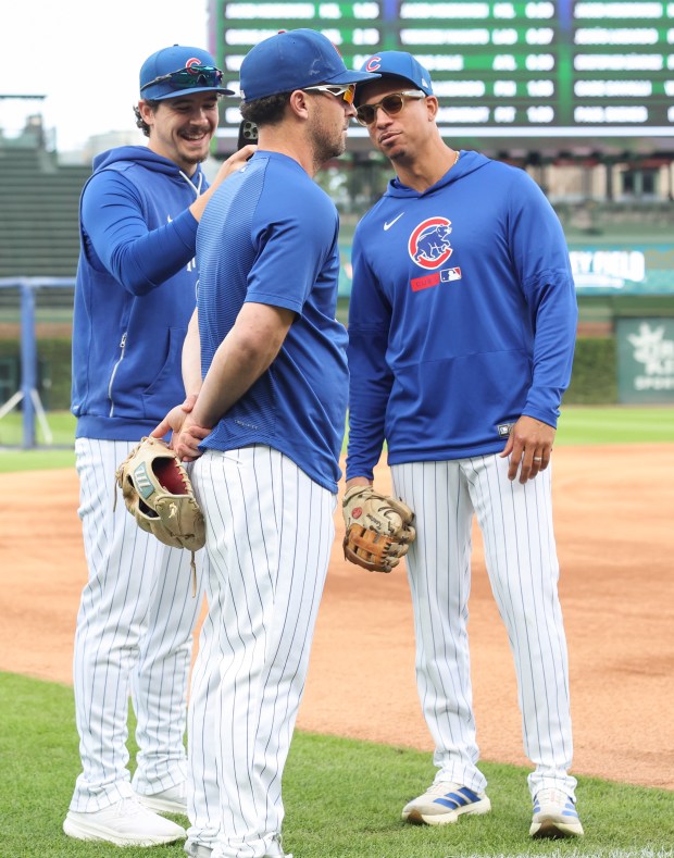 Cubs third baseman Alex Bregman, center, has his picture taken by hitting development coach Ben Martin before a game against the Marlins at Wrigley Field on Sept. 22, 2026, in Chicago. Bregman was injured in the face by a foul ball on Sept. 20. (John J. Kim/Chicago Tribune)