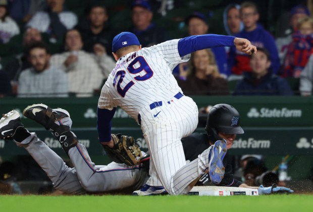 Cubs first baseman Michael Busch (29) is late to tag Marlins first baseman Griffin Conine after Conine hits an RBI single in the 12th inning at Wrigley Field on Sept. 22, 2026, in Chicago. (John J. Kim/Chicago Tribune)