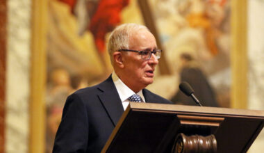 Dr. Manuel Mon speaks at a lectern during Convocation at Jesuit High School in Tampa.