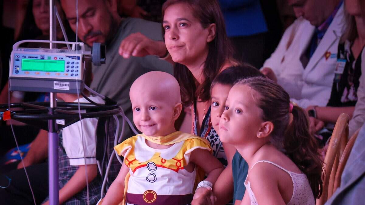 Patient Olivia Montes, center, sits on her mother Macarena Luongo's lap during the remarks of fellow patient Tristen Milano at the groundbreaking ceremony for the future Helen & Jacob Shaham Cancer & Blood Disorders Institute at Nicklaus Children's Hospital in Miami on Thursday, Sept. 10, 2026.
