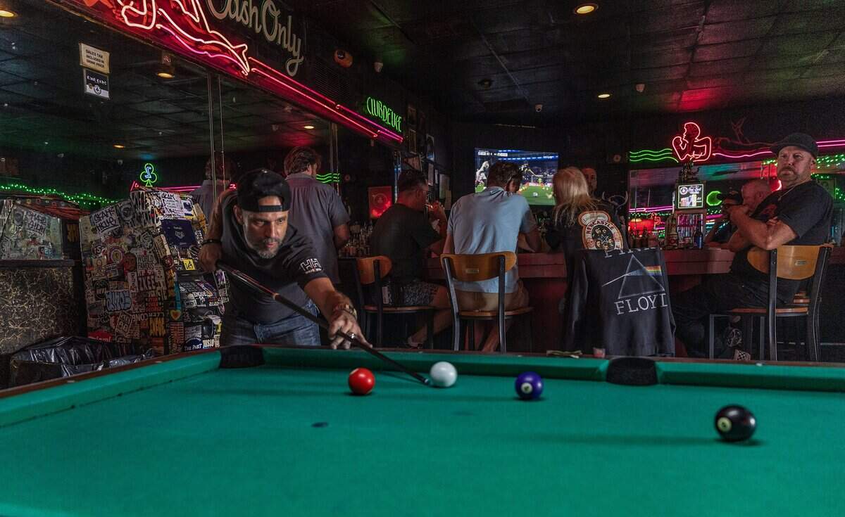 Long time patron, photographer Aaron Ryder, plays pool at Mac's Club Deuce.