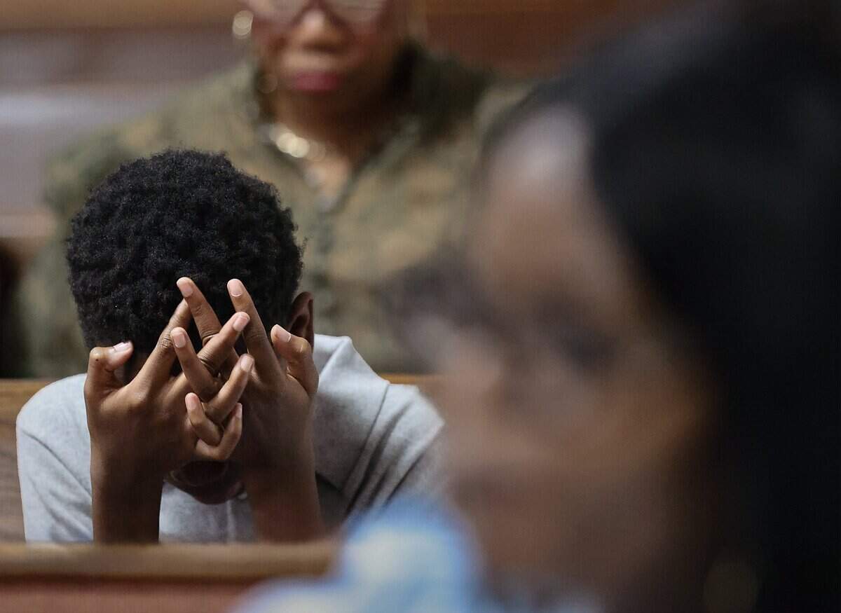 A young boy places his face in his hands during during service as the heavy burden left by the termination of Temporary Protected Status, which has forced tens of thousands of Haitians in South Florida into immigration limbo on Sunday, September 13, 2026, in Miami Gardens, Fla. Many now fear for their safety and have chosen to stay home on Sundays. The decision is not made lightly.