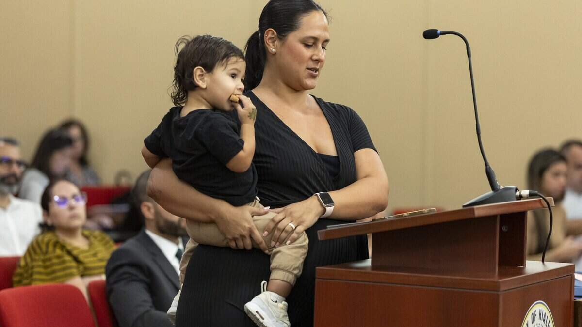 Ileana Rodriguez holds her 1-year-old son, Thiago, as she speaks during a budget meeting at Hialeah City Hall on Tuesday, Sept. 22, 2026, in Hialeah, Fla. Residents and library employees attended the meeting to voice their concerns about the city's proposal to renovate the John F. Kennedy Library.