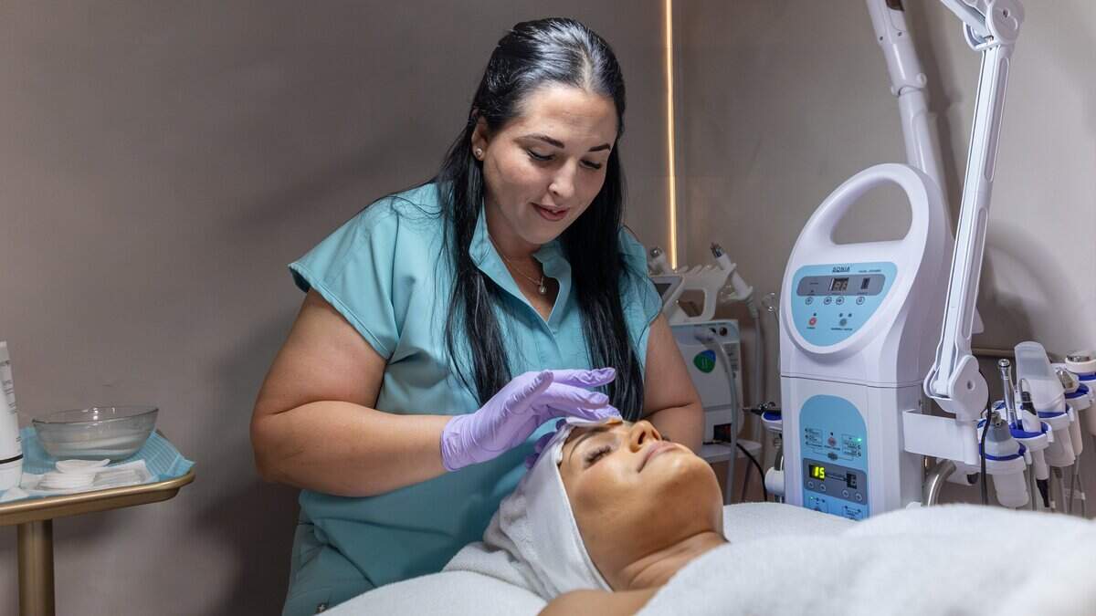 Heidy Martínez, owner of Mimos Skincare, wipes customer Zurelis Bravo's forehead with a cotton pad during a skincare treatment at her store in Miami, Fla., on Friday, July 17, 2026.