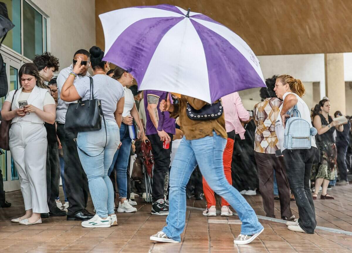 Immigrants seek shelter from rain and thunder while waiting for appointments outside at Miami Immigration Court in downtown Miami on Wednesday, September 9, 2026.
