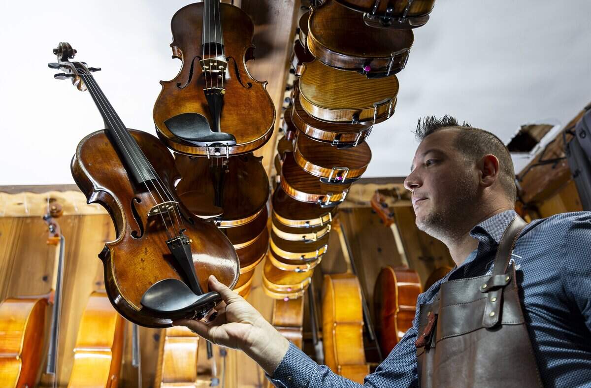 Miami String Haus founder Charles Winters holds a viola he has for sale at his store on Thursday, Aug. 6, 2026, in El Portal, Fla. Miami String Haus is a home-based luthier shop where customers can buy, repair and maintain string instruments, including violins, violas, cellos and double basses.