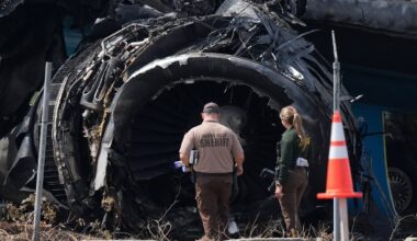 Law enforcement officers walked in front of a destroyed engine as they inspected an Amazon cargo plane in Miami on Sept. 8, two days after it overshot a runway at Miami International Airport.