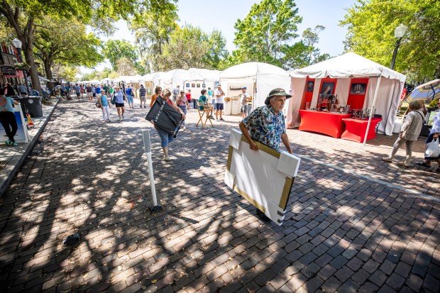 Patrons and visitors wander more than 200 artist booths and purchase artwork at the Winter Park Sidewalk Art Festival on Friday, March 18, 2022.
