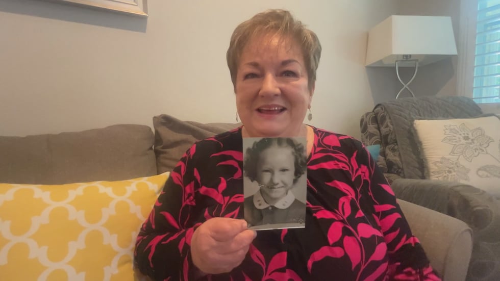 Naomi McCall holds up her first grade picture from 1955.