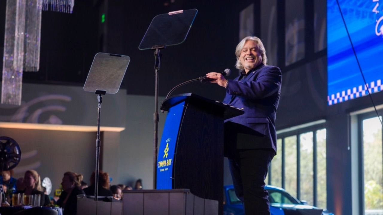 Santiago Corrada smiles while speaking at a podium during Visit Tampa Bay’s annual meeting.