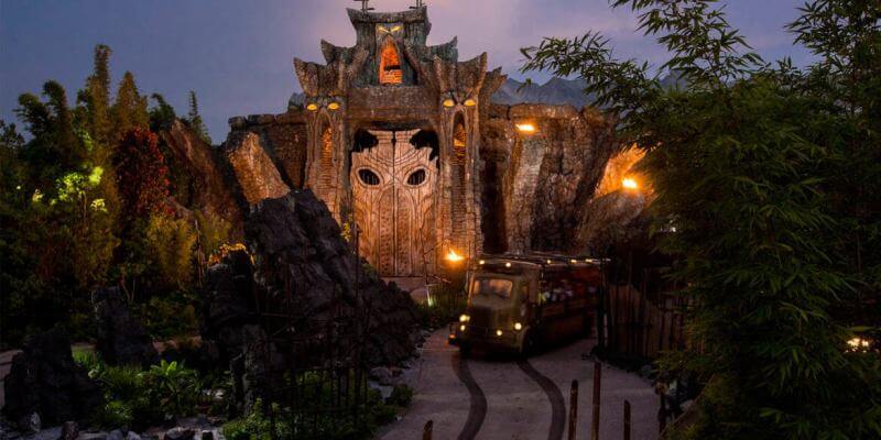 A ride vehicle ventures toward the glowing, intricately carved temple on Skull Island: Reign of Kong at Universal Orlando, set against a dramatic dusk sky that heightens the attraction’s legendary adventure.