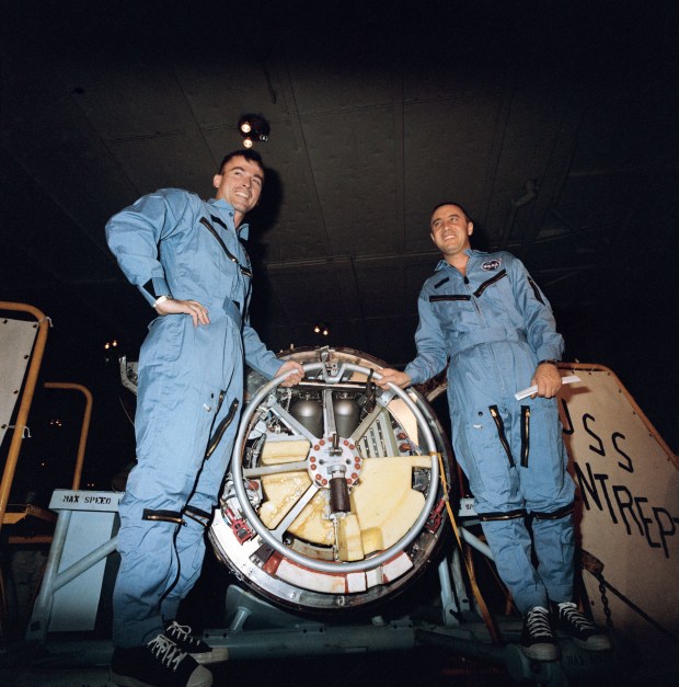 Astronauts John W. Young (left) and Virgil I. Grissom are shown during their first inspection of the Gemini 3 spacecraft aboard the USS Intrepid following their successful Gemini-Titan 3 flight. (NASA File)