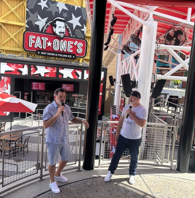Joe Mulvihill (left) and Joey Fatone, founders of Fat One's Hot Dogs, talk with members of the media in front of their Universal CityWalk location, which opens Saturday. (Dewayne Bevil/Orlando Sentinel)