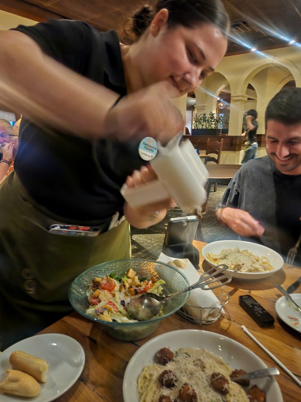 "Say when?" the grater-wielding servers ask. Better be fast or they'll give you the whole block. (Amy Drew Thompson/Orlando Sentinel)