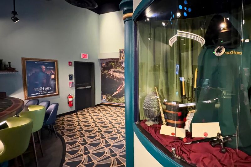 The Traitors upstairs bar costume and props near Jurassic World escape 