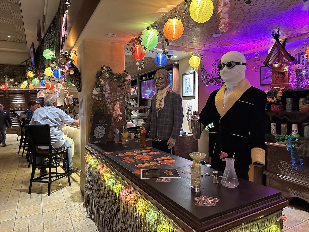 Invisible Man shakes up some cocktails at his bar