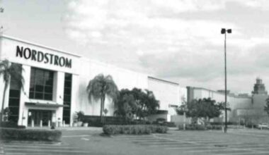 Black-and-white archival photo of the Nordstrom exterior at International Plaza in Tampa, with palm trees and an empty parking lot.