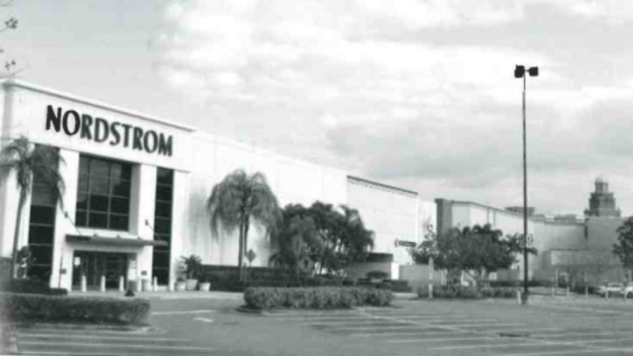 Black-and-white archival photo of the Nordstrom exterior at International Plaza in Tampa, with palm trees and an empty parking lot.