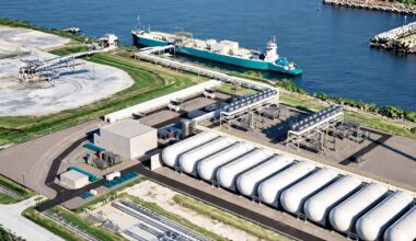 Aerial view of a carbon dioxide terminal with storage tanks and a cargo vessel at the port