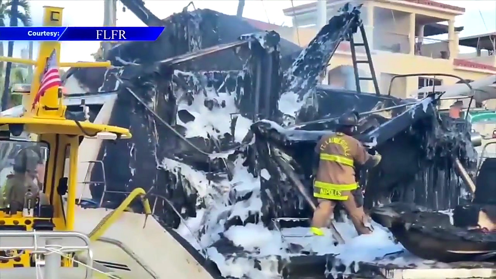 A Fort Lauderdale firefighter douses hot spots inside the burned hull hours after the blaze.