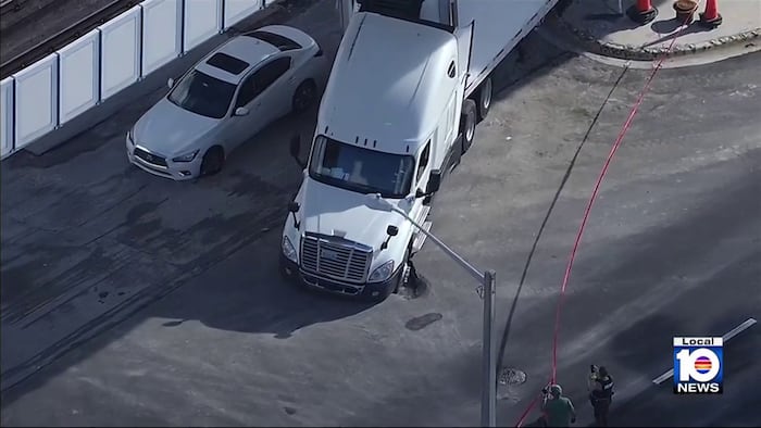 Sinkhole leaves tractor-trailer, sedan stuck in northwest Miami-Dade roadway