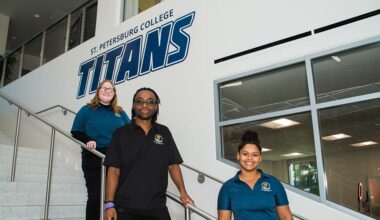 a female, male and female student in SPC polo shirts standing on staggered stairs