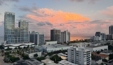 Miami Beach skyline at sunset with pink clouds over the ocean.