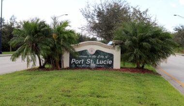 A welcome sign for the city of Port St. Lucie surrounded by palm trees and grass.