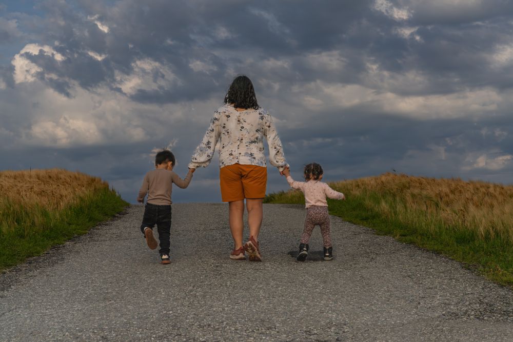 Woman taking care of her children on a rural road in America.